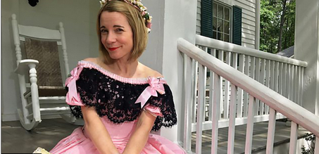 a woman sitting on a porch in a pink Civil War era dress